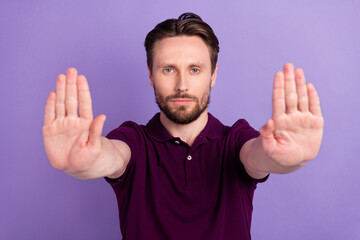 Photo of young man show arms rejection forbidden ban enough stop symbol isolated over violet color...