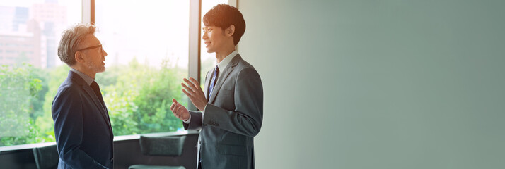 ロビーで会話するエグゼクティブ男性と若手社員
