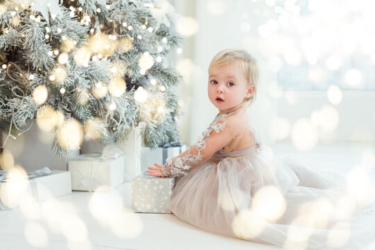 Happy excited child holding christmas gift box. Girl with Christmas present in decorated room. christmas and people concept. New Year Happy holidays. kid satisfied with present.