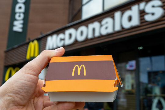 Big Mac box in hand against background of McDonald's restaurant. Minsk, Belarus - may, 2022