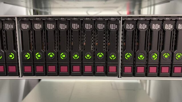 HDD SATA Server. LED lamps blink in data server with multiple hard drives in big rack.