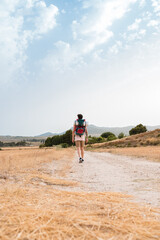 Fototapeta premium Man walks with a backpack of a hiker through a mountainous landscape