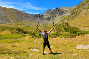 hiker man and backpack in the Pyrenees mountain- success, travel, sport concept
