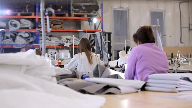 Seamstresses at a garment factory. Workflow at a textile factory. Modern sewing workshop. Inside a textile factory