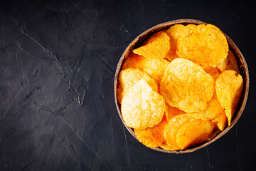 golden crispy potato chips on a dark background