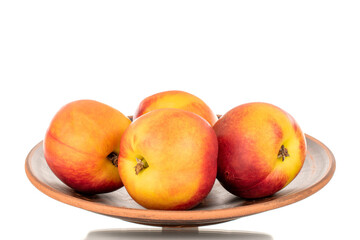 Several juicy organic nectarines with a ceramic plate, close-up, isolated on a white background.