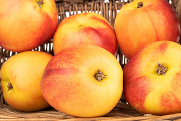 Several juicy organic nectarines with a basket, close-up.