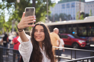 young woman taking a selfie on the street in a big city