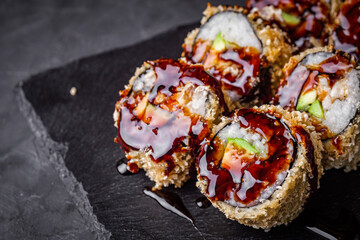 delicious sushi rolls on a black stone background