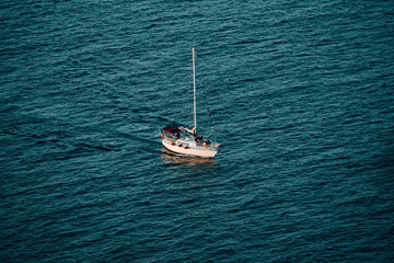 Fototapeta premium Boat floating in sea at sunset