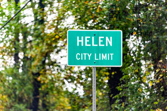 Direction sign on road street for Helen, Georgia Bavarian village town in traditional German European architecture city limit in green color in autumn fall closeup with nobody