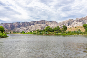 Green River Campground water in Dinosaur National Monument Park with green plants and canyon rock...