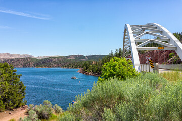 Dutch John, USA road with Flaming Gorge Reservoir Bridge with white color and blue lake river and...