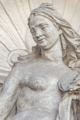 Old sculpture of a sensual woman nymph bathing at the fountain in Zwinger gardens at historical and museums downtown of Dresden, Germany.