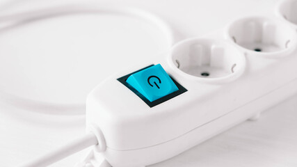 Modern white electric extension cord with a button on a white background