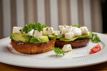 sandwiches with avocado and poached egg on a wooden table in a restaurant
