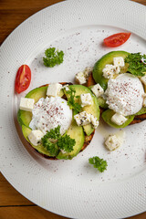 sandwiches with avocado and poached egg on a wooden table in a restaurant
