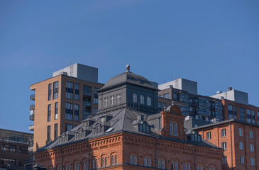 Roofs and facades of rebuilt old factory and new apartment buildings at the pier Kvarnholmen a sunny summer day in Stockholm