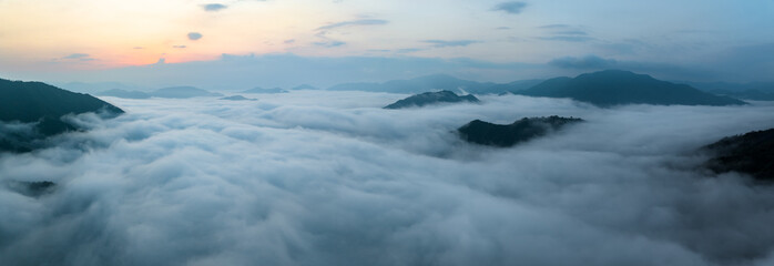 Obraz premium Panorama of sea of clouds around mountain peaks at sunrise