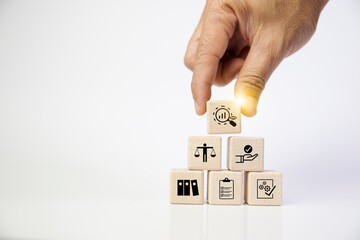 Audit business concept. Examination and evaluation of the financial statements of an organization; income statement, balance sheet, cash flow statement. Holding wooden cubes with audit icon.