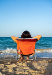 Mujer morena en la playa mirando al horizonte