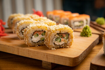 Japanese cuisine. Rolls with sauce on a wooden plate
