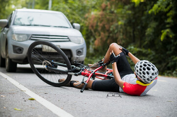 An Asian mountain biker was hit by a car on the road. A mountain biker was injured in a collision...