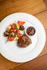 Steak with garnish and sauce on a plate
