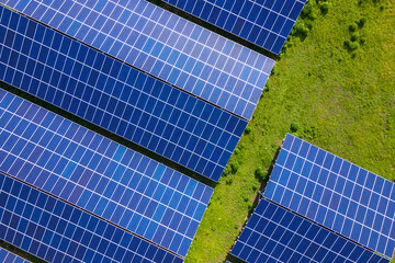 Aerial view of large sustainable electrical power plant with rows of solar photovoltaic panels for...