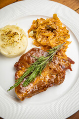 Steak with garnish and sauce on a plate
