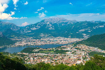 The city of lecco, shot from above, by day, with the surrounding mountains.
