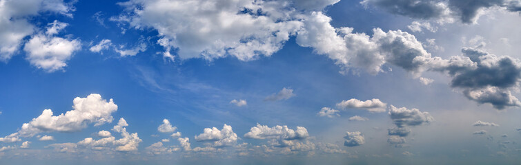 Bright landscape of white puffy cumulus clouds on blue clear sky