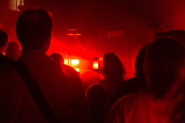 The audience watching the concert on stage in big concert club.