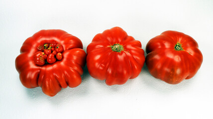Tomatoes isolated on white. Fresh ripe red juicy tomato close-up. Three appetizing tomatoes view from above. Fresh vegetables.