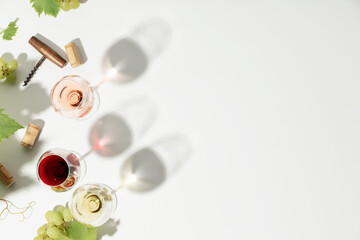 Wine composition with beautiful sunlight and shadows on white background. Top view, flat lay