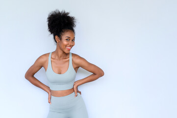 Beautiful young African American girl posing with fitness clothes isolated over white background....