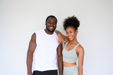 portrait of young couple of African Americans posing in fitness clothes over white background....