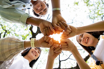 Close up, hands Teamwork group of multi racial people meeting join hands at park. Diversity people...