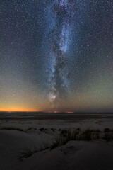 Bright vertical milky way over the north sea on Amrum island Germany with sunset glow