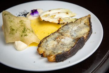 Fish dish with garnish on a plate in a restaurant
