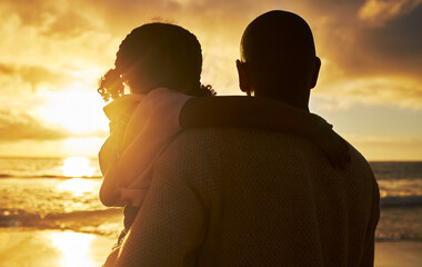 Silhouette of a loving father and daughter watching the view at sunset. Family looking at the beautiful golden sky while on holiday. Little girl and dad bonding and enjoying time together on vacation
