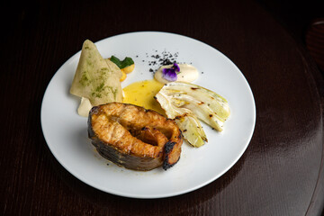 Fish dish with garnish on a plate in a restaurant
