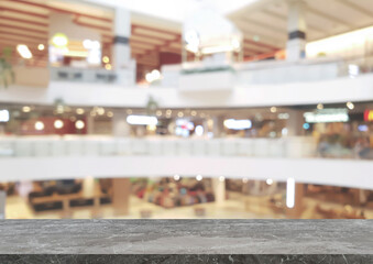 empty grey marble table in front of blurred background of shopping mall atrium can be used for...