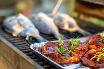 Sea bream dorado fish placed on the grill. Fresh sea food with herb and lemon. Summer bbq