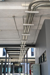 Metal power pipe on ceiling. Electrical conduits system, metal pipeline installed on building ceiling..