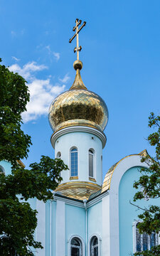 Temple of Kazan Icon of Mother of God. Golden domes with orthodox crosses against background of blue sky. Close-up. Russian Orthodox Church, Ekaterinodar diocese. Krasnodar, Russia - June 16, 2022