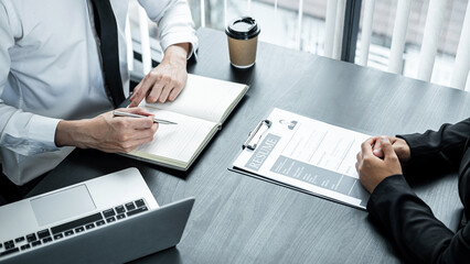 Businesswoman candidate present and explaining her profile to selection committee manager and recruiter reading a resume during a job interview in office
