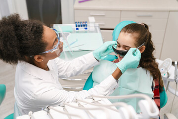 Black dentist working with patient in dental clinic