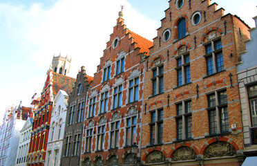 Fototapeta premium Bruges, Brugge, facades of ancient houses of an unusual shape against the blue sky, ancient architecture, Belgium