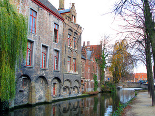 Fototapeta na wymiar Brugge, Bruges typical street in the old town, old houses with tiled roofs, canal, autumn, Belgium. 